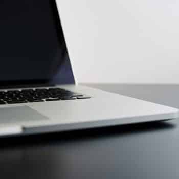 silver laptop computer on black table
