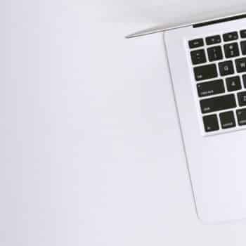 Free Aerial view of a sleek laptop keyboard on a clean, white surface, ideal for tech backgrounds. Stock Photo